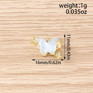 Gros plan d'un pendentif papillon plaqué or avec ailes irisées et petites étoiles
