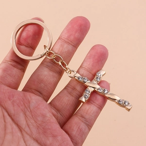 Golden Christian cross keychain with sparkling rhinestones and twisted metal texture design