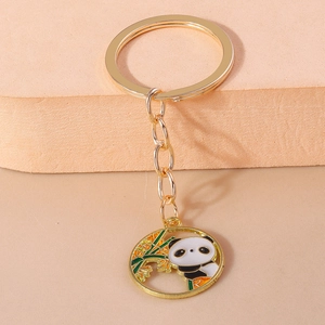 Detail eines goldenen Panda-Schlüsselanhängers mit Emaille-Panda am Bambusast