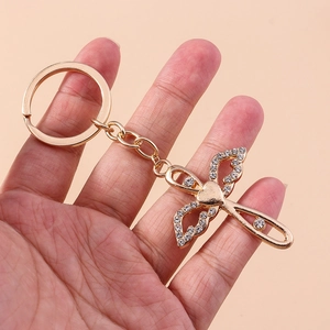Gold crystal cross keychain with rhinestone butterfly wings and heart detail handheld
