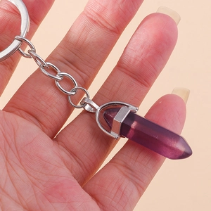 Detail view of purple hexagonal crystal pendant keychain held in hand with silver metal ring