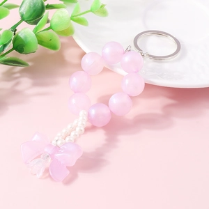 Detailed view of pink pearl beaded keychain with translucent bow and silver metal ring