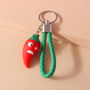 Porte-clés piment rouge avec lanière tressée verte et détail de l'anneau argenté