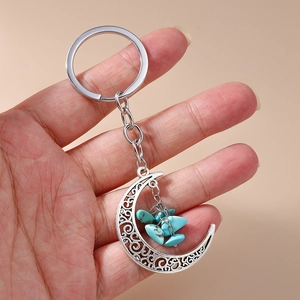 Detailed close-up of a bohemian hollow moon keychain with blue turquoise stones