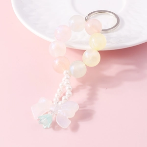 Detailed shot of iridescent beaded keychain with bow pendant and pearlescent beads