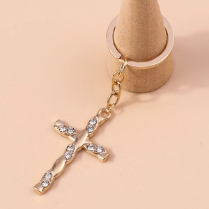 Detailed view of a gold cross keychain with sparkling crystal rhinestones and flat key ring