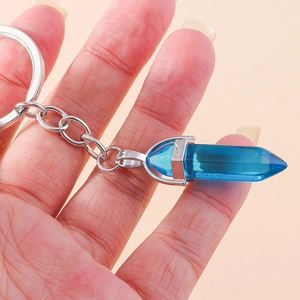 Close-up of hexagonal blue crystal pillar pendant keychain with silver metal clip