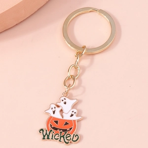 Detail of Halloween pumpkin and ghost keychain with Wicked text on pink background