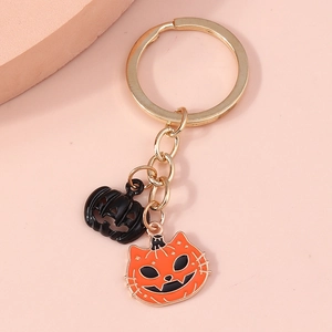 Detail of Halloween keychain with black and orange pumpkin charms on a golden ring