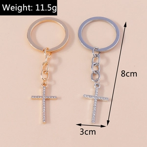 Detailed view of silver and gold rhinestone cross keychains with specific size measurements