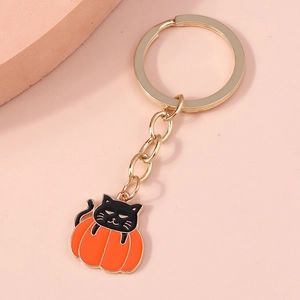 Detail of Halloween pumpkin and black cat keychain with golden ring and chain