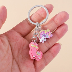 Close-up of cute pink alpaca and rainbow cloud keychain hanging on a metal ring
