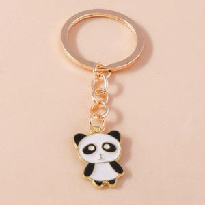 Detail eines süßen Panda-Schlüsselanhängers mit goldenem Metallring auf rosa Hintergrund