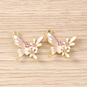 Détail de pendentifs papillon avec émail, strass et perles pour la création de bijoux DIY
