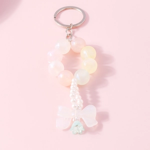 Detailed view of beaded bow keychain with pastel frosted beads and white faux pearls