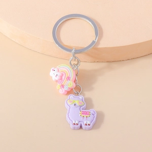 Detail shot of a cute pink rainbow cloud and purple alpaca resin keychain pendant