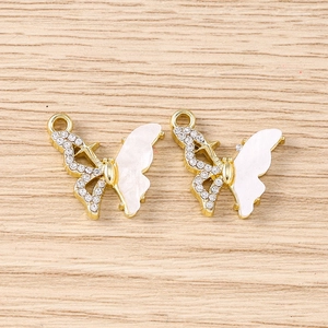 Détail de pendentifs papillons dorés avec strass pour création de bijoux DIY