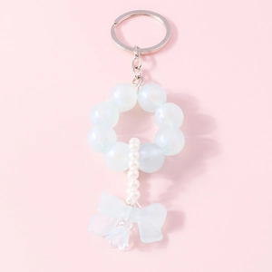 Detail of beaded keychain with blue frosted beads, white pearls, and a bow pendant