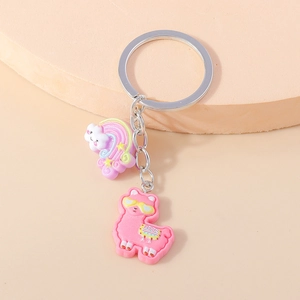 Detail showing the pink resin alpaca and rainbow cloud charms on a silver metal keychain