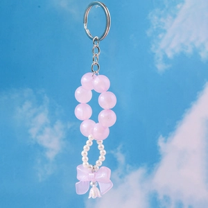 Detailed view of pink beaded keychain with pearl loops and translucent bow pendant
