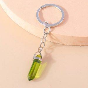 Macro detail of hexagonal green crystal pendant keychain with silver metal clip