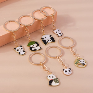 Süße Panda Schlüsselanhänger Set mit goldenen Ringen und Emaille Anhängern auf beige