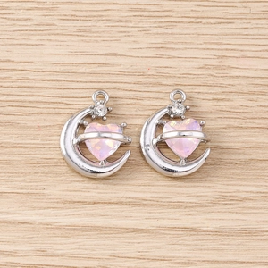 Détail de breloques baroques lune et cœur en argent avec pierres roses et étoiles
