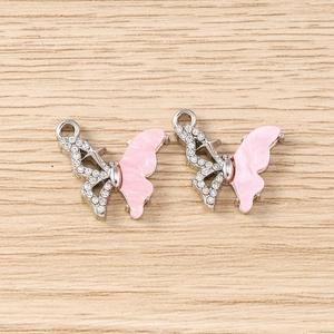 Détail d'un pendentif papillon rose avec strass et métal argenté pour bijoux DIY créatifs