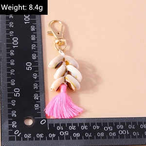 Detail view of beach shell keychain with pink tassel and gold clasp, length 12cm