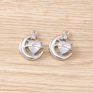 Détail de pendentifs cœur lune et étoile en argent avec pierres d'opale bleues