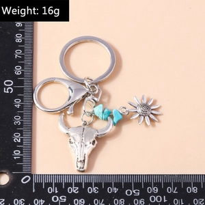 Detailed view of vintage silver bull head keychain with turquoise beads and sunflower charm
