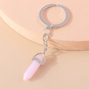 Detailed macro view of a pink hexagonal crystal bullet pendant on a silver keychain loop