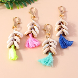 Detailed close-up of shell keychain set with colorful tassels and gold lobster clasps