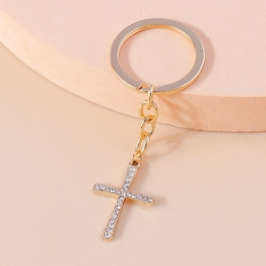 Detailed view of a gold-plated cross keychain featuring sparkling white rhinestones and ring