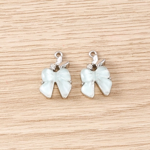Détail de pendentifs nœud bleu clair avec accents de papillon en argent et strass