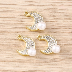 Vue détaillée de pendentifs lune avec zircons et perles sur une base en métal doré