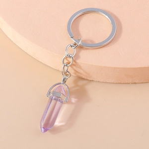 Close-up of a purple hexagonal crystal bullet pendant on a silver metal keychain