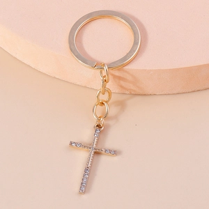 Detailed close-up of golden Christian cross keychain with sparkling crystal rhinestones