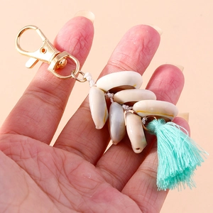 Handmade seashell keychain with white natural shells and mint green cotton tassel fringe