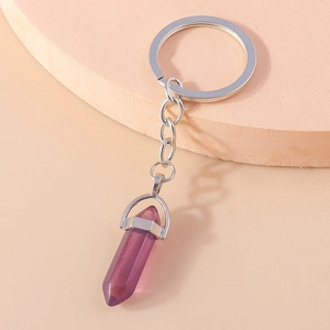 Detailed macro view of a translucent purple hexagonal crystal bullet keychain with silver ring
