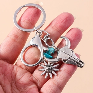 Macro view of vintage silver bull skull and sunflower keychain with turquoise beads