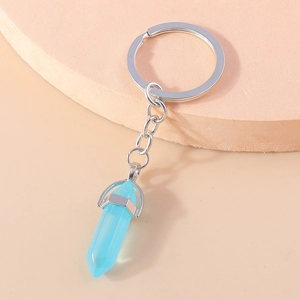 Detailed view of light blue hexagonal crystal pendant keychain on a geometric stand