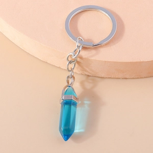 Detail of dark blue hexagonal crystal pendant with silver metal keychain and ring