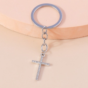 Close-up of silver cross keychain featuring sparkling white rhinestones and secure ring