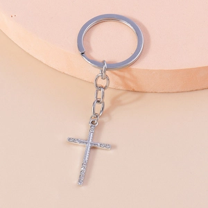 Macro view of silver Christian cross keychain with sparkling white rhinestones inlay
