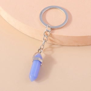 Macro detail of a hexagonal purple crystal pendant on a silver metal keychain ring