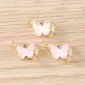 Vue détaillée de trois pendentifs papillon rose clair avec étoiles dorées pour bijoux DIY