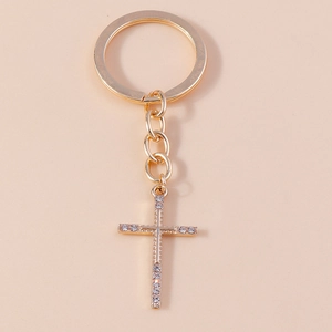 Macro detail of the sparkling rhinestone cross pendant on a golden keychain