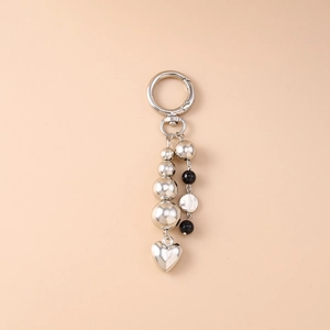 Exquisite silver beaded keychain featuring heart pendant and bow accents on light background