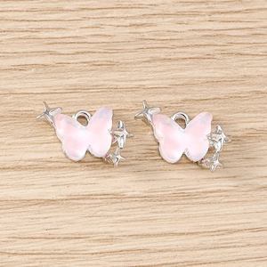 Détail de pendentifs papillon roses avec cadres argentés et anneaux de suspension DIY